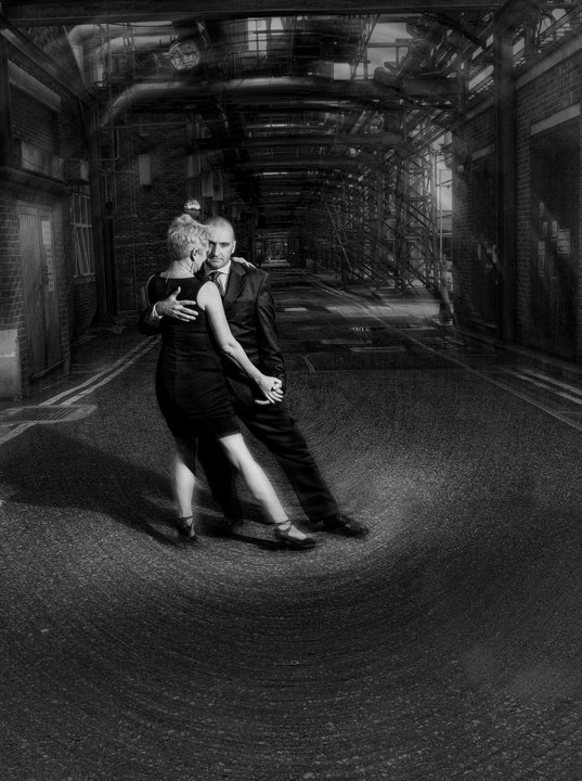 David and Ann dancing tango in a moody black-and-white warehouse setting